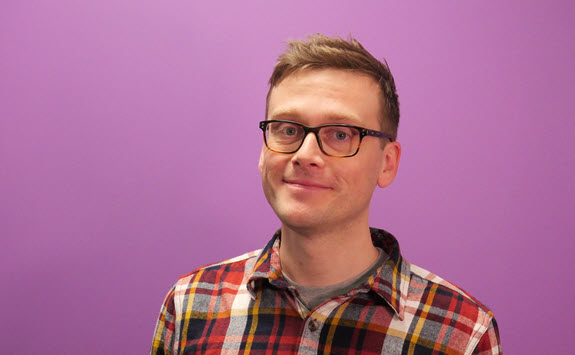 Photograph of Simon Young with a purple background.